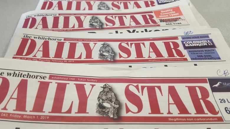 A stack of 'Daily Star' newspapers laid out on a table.