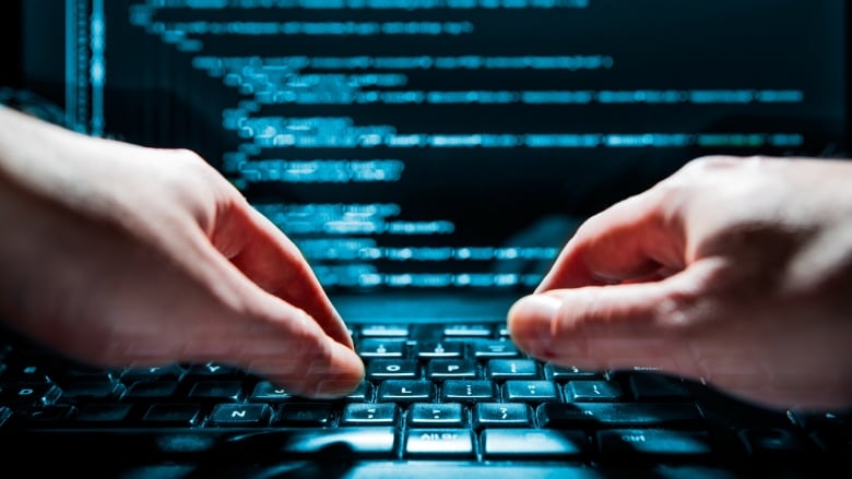 A pair of hands typing on a green and black keyboard. 