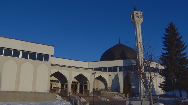 An exterior view of a mosque under a bright blue sky.