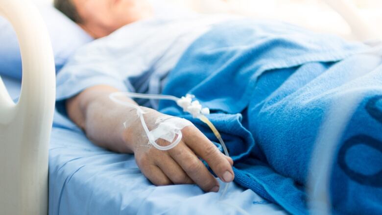 Person lying down in hospital bed