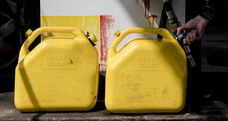 Two yellow jerrycans sit on the ground.