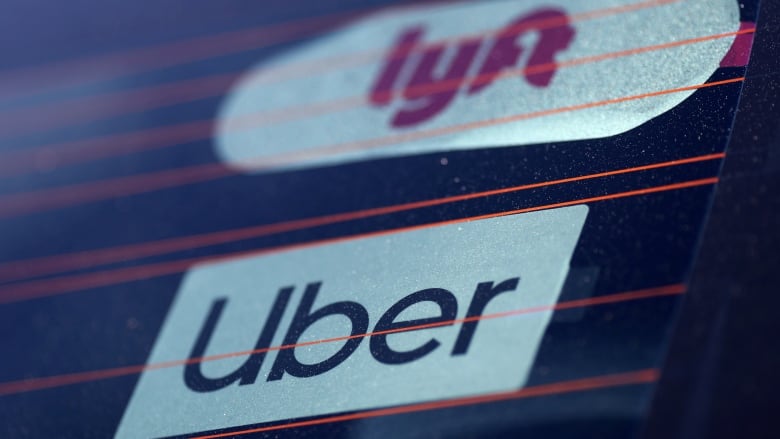 FILE PHOTO: Uber and Lyft signs are seen on a car in Redondo Beach, California, U.S., March 25, 2019.  