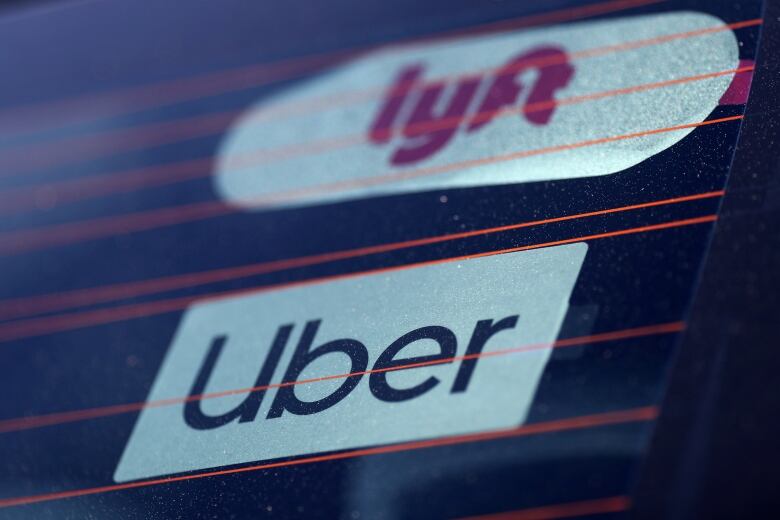 FILE PHOTO: Uber and Lyft signs are seen on a car in Redondo Beach, California, U.S., March 25, 2019.  