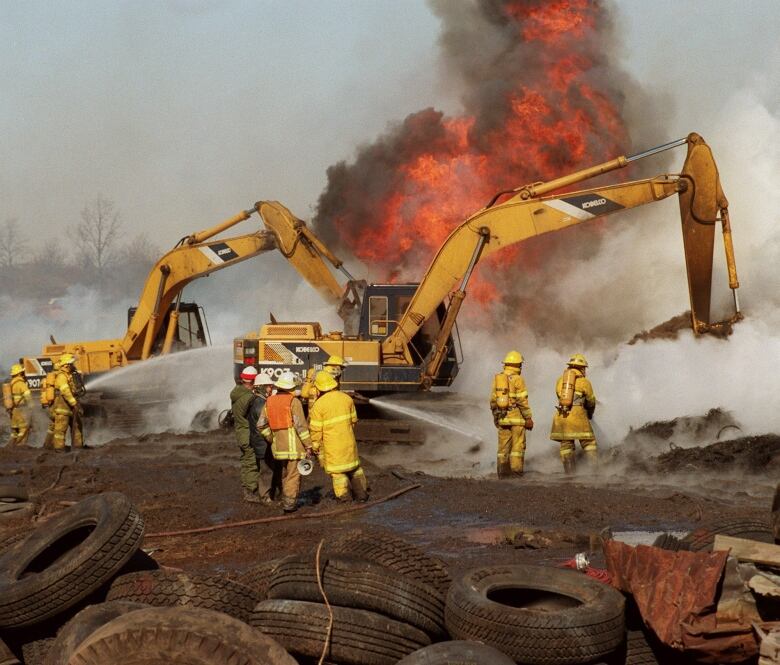 Firefighters battle a tire fire