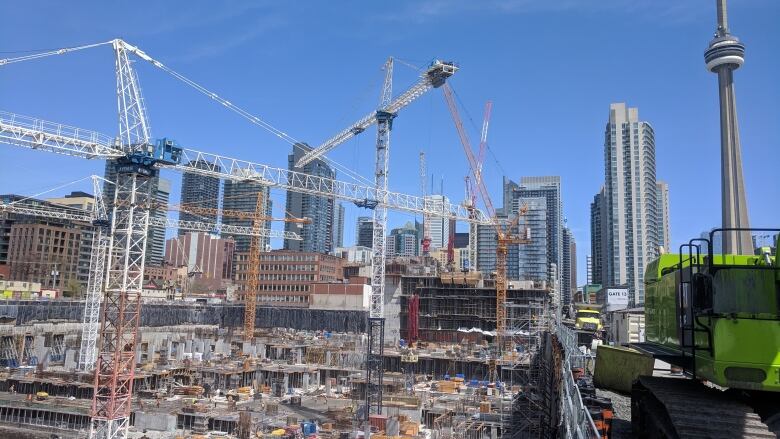 A construction site with large cranes in the background.