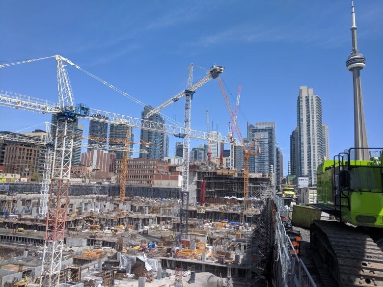 A construction site with large cranes in the background.