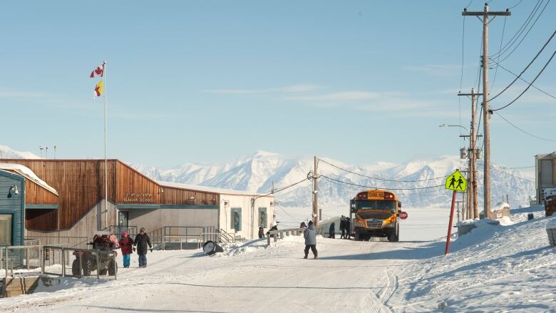 A school bus dropping off kids in a school in the Arctic