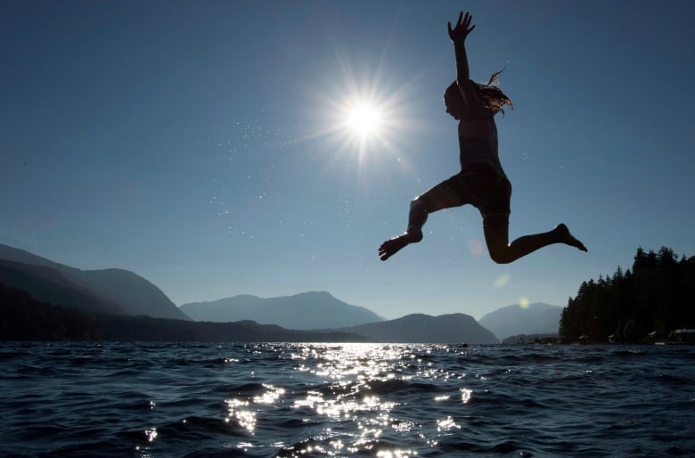 a girl  jumps into a lake