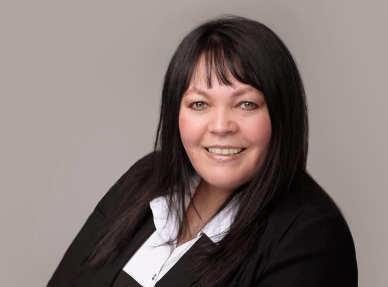 A woman poses for a photo in a suit. 