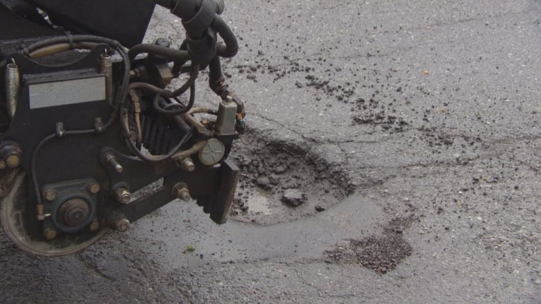 The Python 5000 first cleans out the hole in the pavement before it fills them with asphalt.