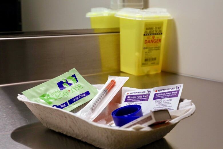 A dish of sterile needles, alcohol swabs, and drug test strips. 