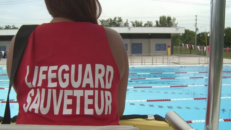 A lifeguard surveys a pool.