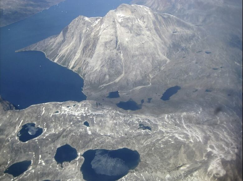 An aerial view of melt water lakes on the edge of an ice cap in Nunatarssuk, Greenland. 