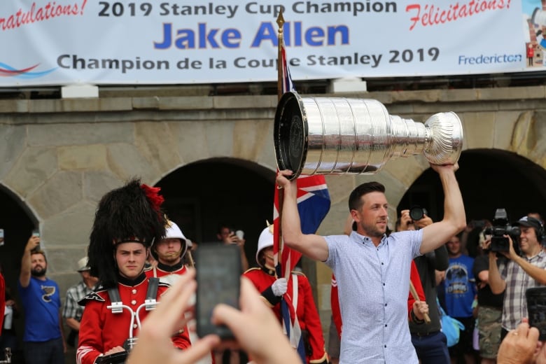 A man holding the Stanley Cup above his head