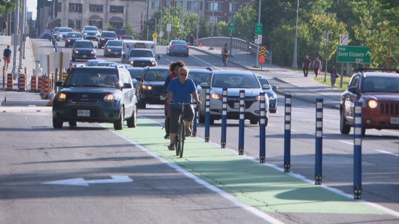 Cyclists use a green painted lane in between lanes of car traffic