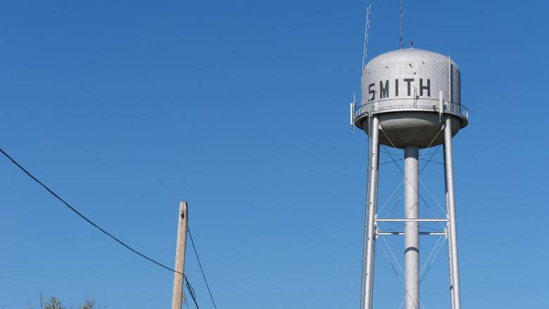 A water tower is seen against a blue sky.