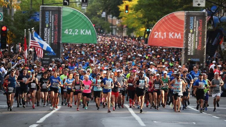 A group of people run in the street.