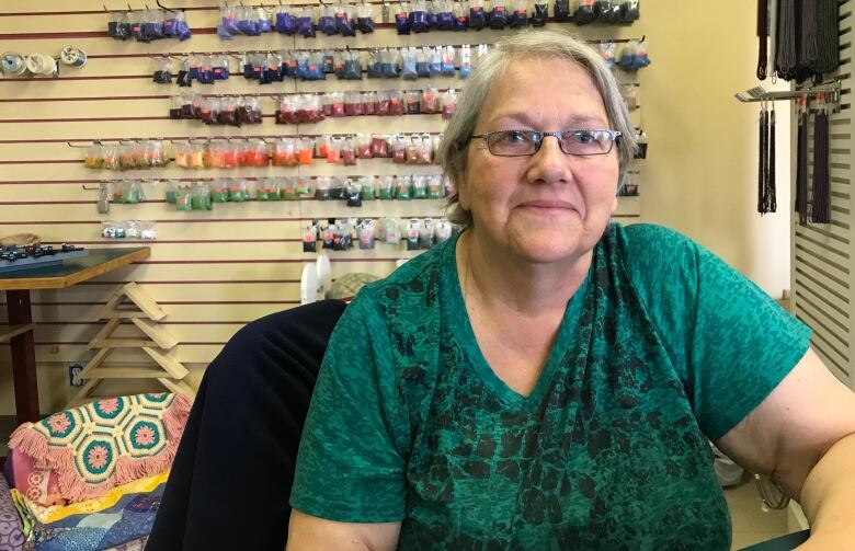 A woman wearing a green T-Shirt and glasses 