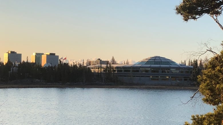 City buildings are seen from afar, across the water.