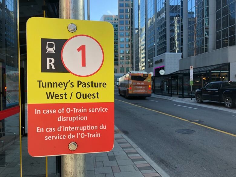 A sign for R1 replacement buses on a street-level transit station.