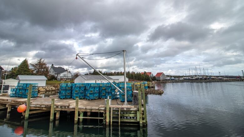 A fishing dock with lobster traps on it, below cloudy skies.