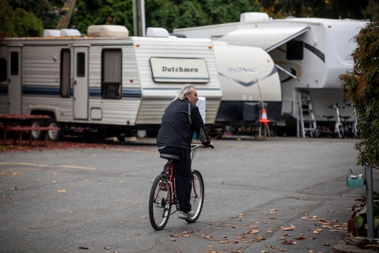 A man bikes through an RV park.