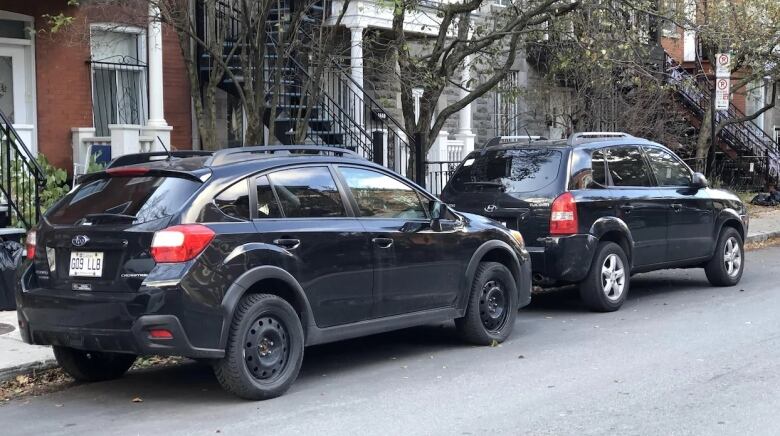 two suvs parked on the street.