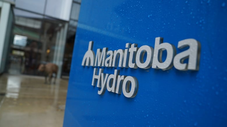 A closeup of a blue sign outside a building with a logo reading 