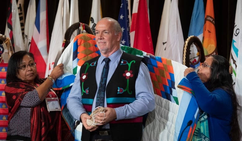 John Horgan is presented with a blanket during a ceremony