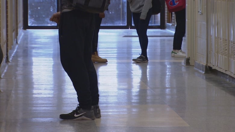 Students are seen in the hallway of a school.