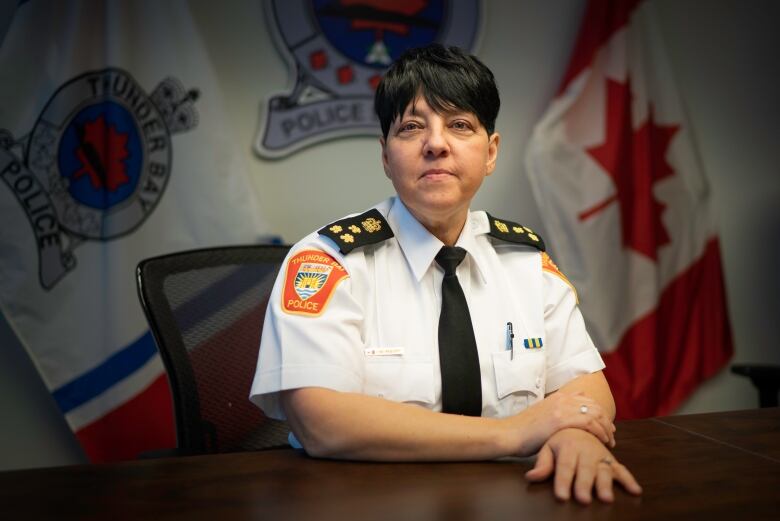 A woman in a police uniform poses for a photo. 