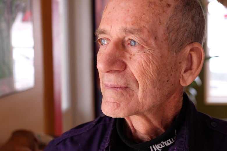 Close up of a man's face, from the profile. He's older, with wrinkles and liver spots and thin, grey hair.