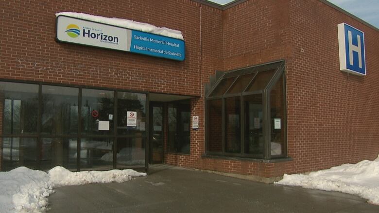 A brick building features a large letter H on the right and a sign for Horizon Health above the main door. Snow is on the ground. 