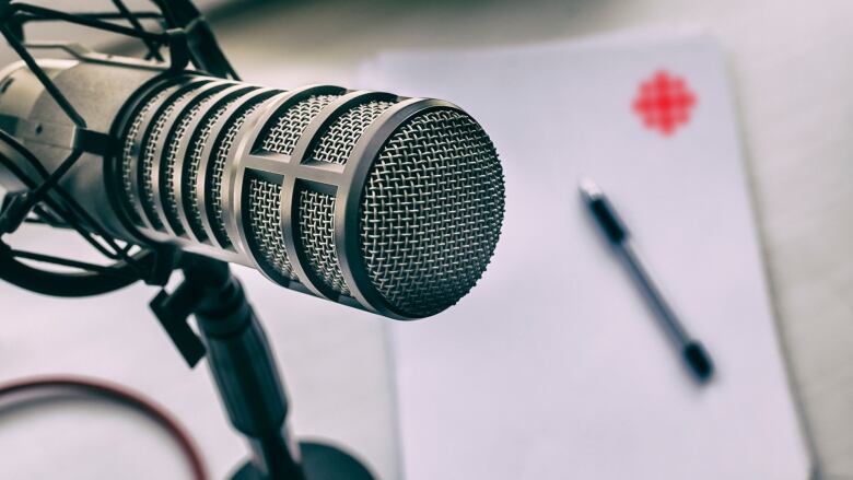 A microphone in front of a CBC branded paper.