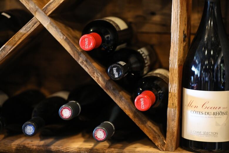 A closeup of a four bottles of wine in a wine rack.