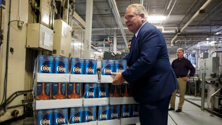 Ontario Premier Doug Ford holds a case of beer