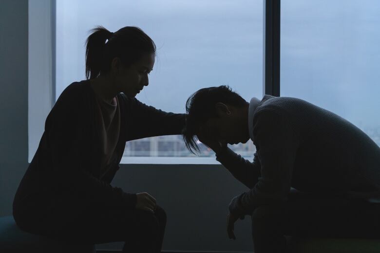 A woman comforts a person in distress. 