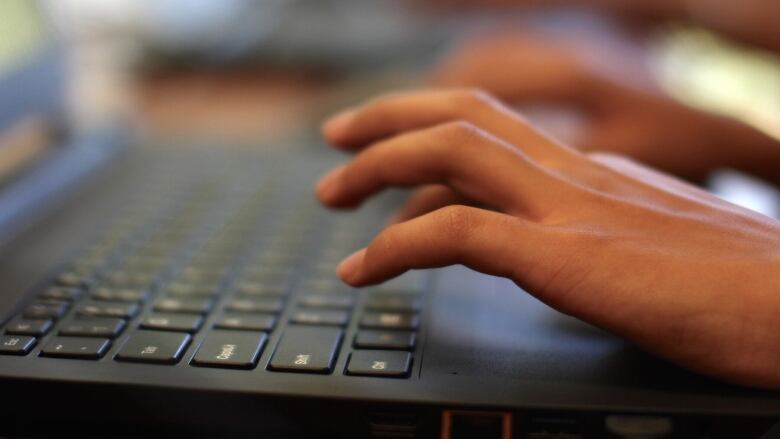 A person typing on a laptop computer.