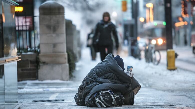 Homeless person panhandling on Toronto street.