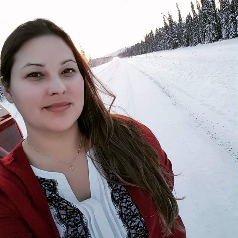 Hilary Deneron wears a red jacket outside in front of a snowy road.