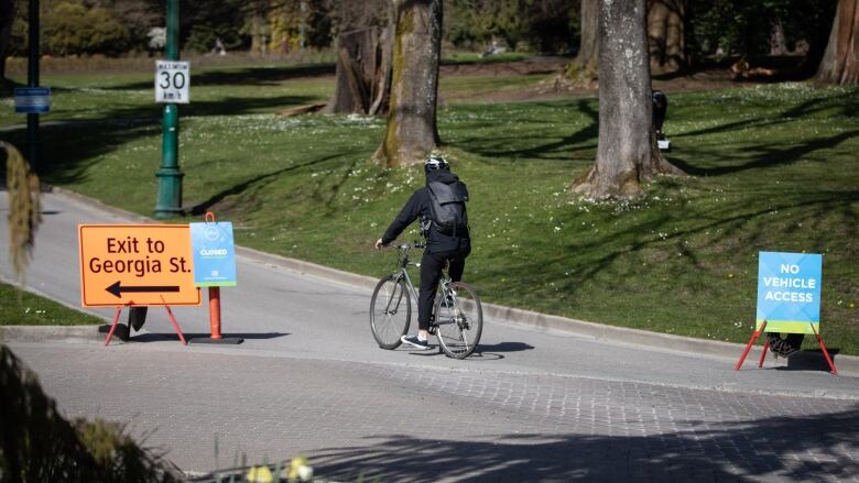 A cyclist riding on a road in Stanley Park in spring.