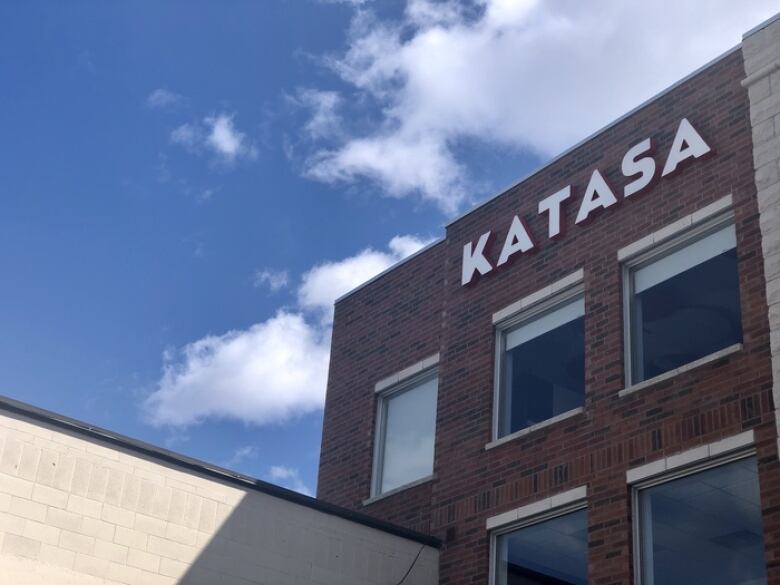 A brick building with a developer's logo on the side.