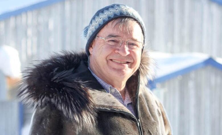 A portrait of a smiling man outdoors.