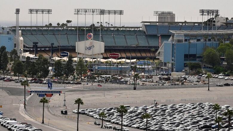 A parking lot with Dodger Stadium in the background. 