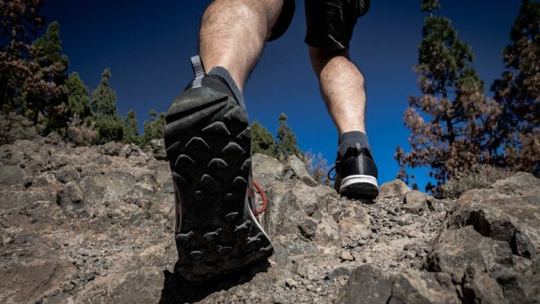 A man hikes up a rocky hill.