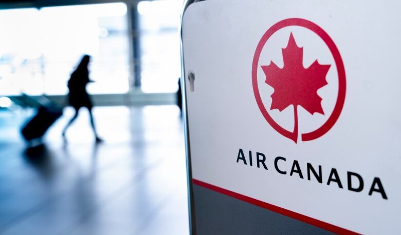 A sign reading 'Air Canada' with a person in silhouette behind it.