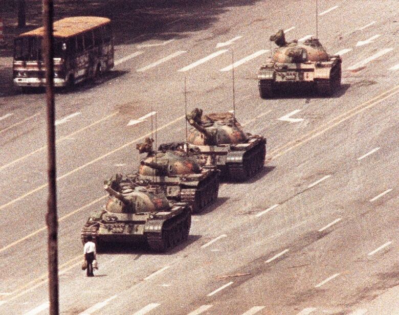 A man stands in front of a convoy of tanks in Beijing 