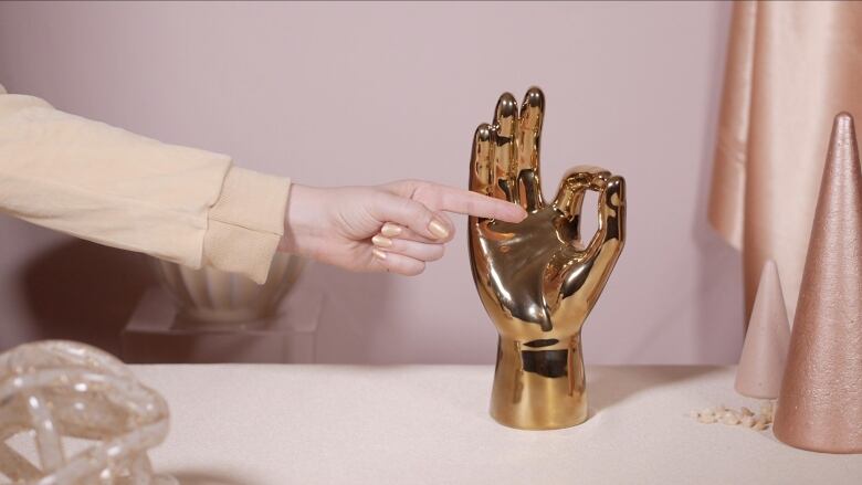 A brass casting of a human hand positioned in the 