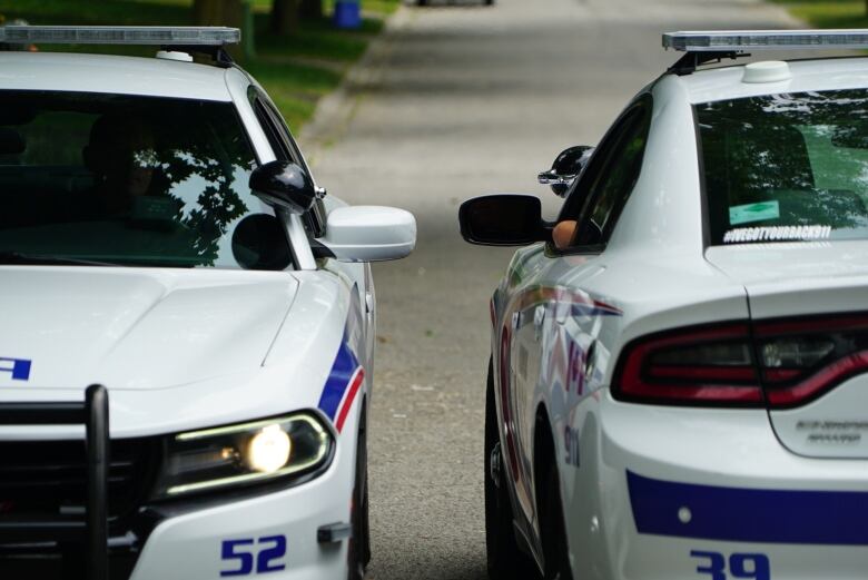 two cop cars parked together to officers can talk