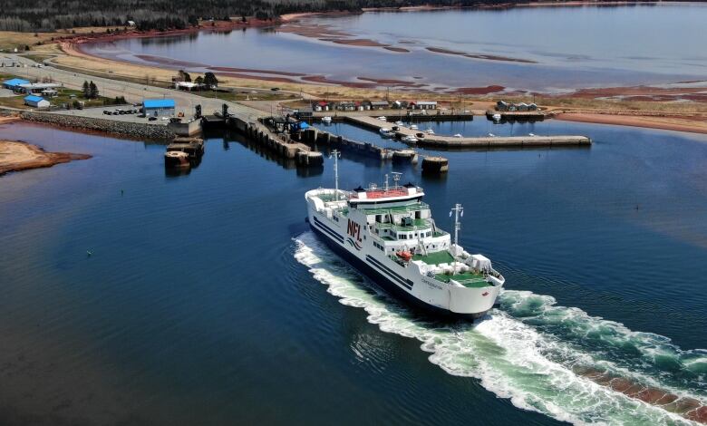 A large passenger and vehicle ferry is shown approaching the shore of Prince Edward Island. 